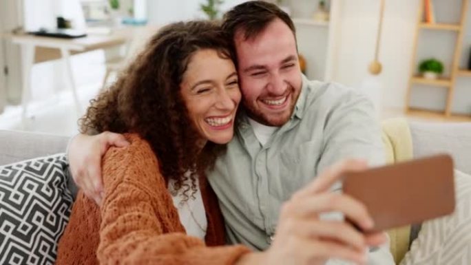 有趣的是，手机自拍，并在家庭客厅沙发上使用技术带着幸福的微笑。女友和男友的愚蠢，喜剧和喜剧照片，幸福