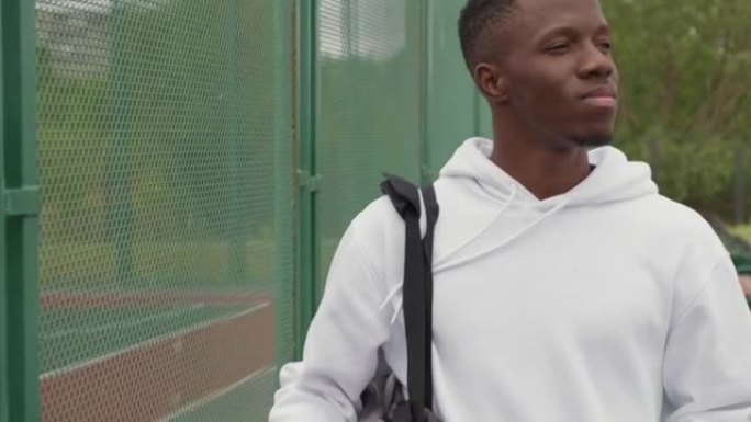 非裔美国人在室外篮球场旁行走