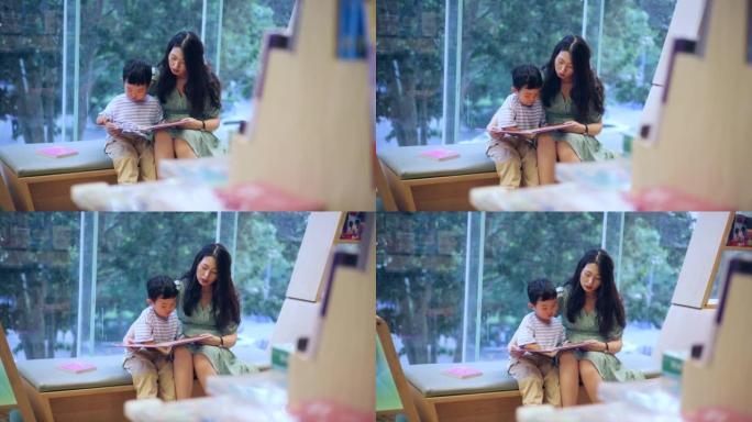 母子坐在窗边一起读书