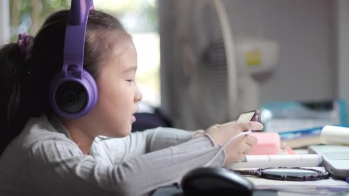 亚洲小女孩在家用智能手机学习