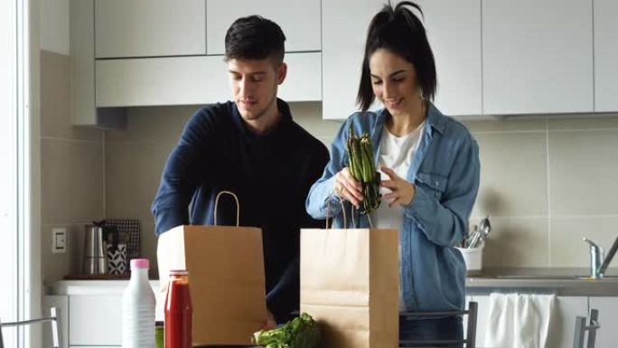 一对年轻幸福的恋爱夫妇的真实照片很有趣，可以整理一份杂货订单，并在家中交付新鲜食品