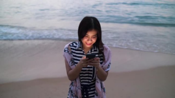 海滩上的女人在智能手机上发短信