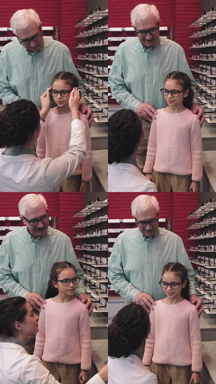 小女孩在配镜师选择眼镜