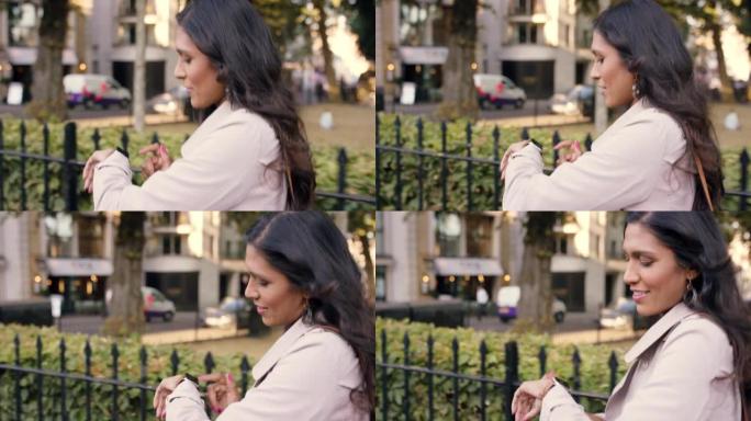 4k视频片段，一名年轻女子在城市外散步时检查手表