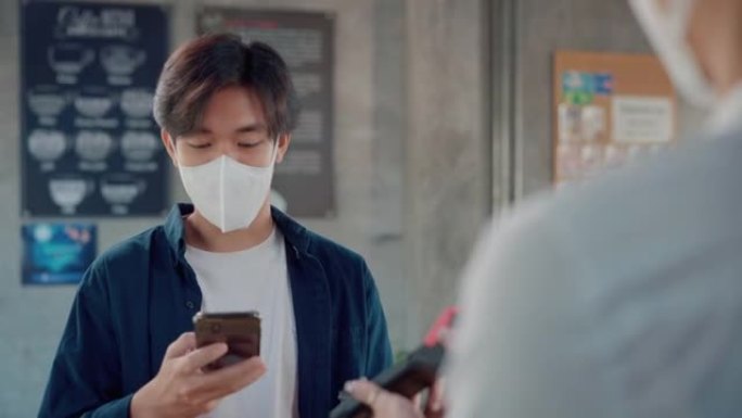 顾客在咖啡店用手机付款。