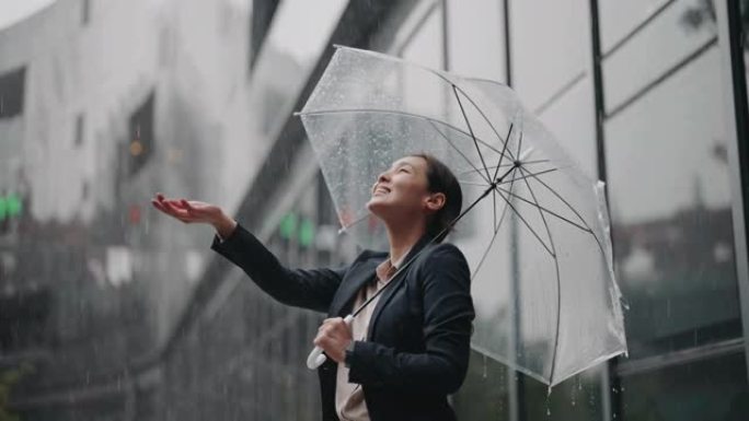 亚洲女商人站在雨中撑着伞