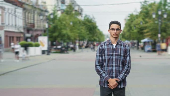 一个人站在步行街上的漂亮中东男子的时间流逝肖像