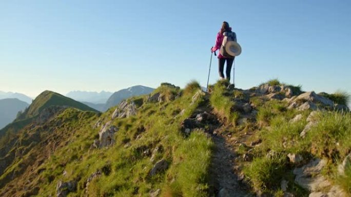 背着背包的SLO MO年轻女子在山脊上行走