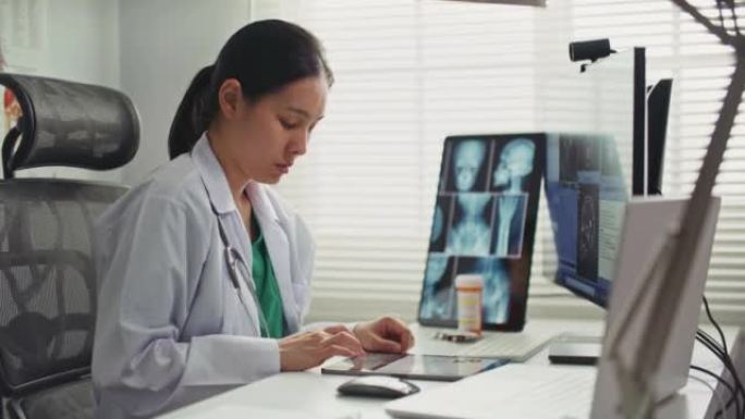 医生在诊所用数字平板电脑为病人写处方
