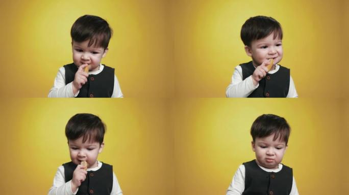 一个可爱的漂亮婴儿在吃柠檬。一个孩子品尝生柠檬。顽皮的小男孩吃水果。抱着吃的美味的小孩。有趣的表达情