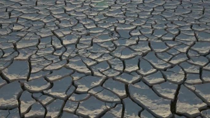 气候变化。由于气候变化和全球变暖造成的干旱，干旱大坝的图案化开裂的泥浆表面的特写视图