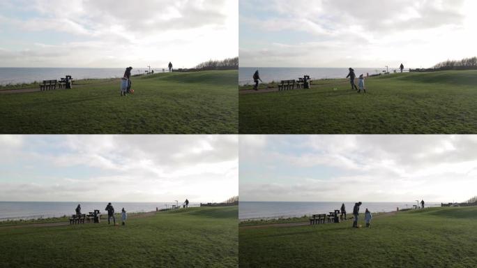 父子关系爸爸和孩子两人踢足球在海边陪伴开