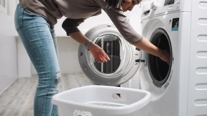 亚洲妇女在洗衣机上装脏衣服