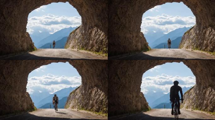年轻的公路自行车手骑在山口上，穿过岩石隧道