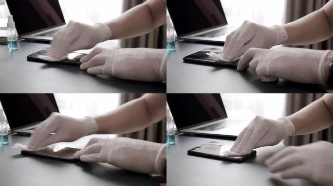特写亚洲男子使用消毒湿巾清洁他的智能手机或移动设备的屏幕，以清洁和抗菌从冠状病毒或新型冠状病毒肺炎问