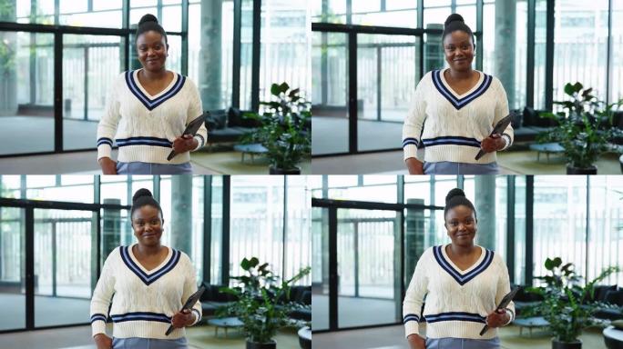微笑的非洲妇女站在办公室的数字平板电脑的肖像