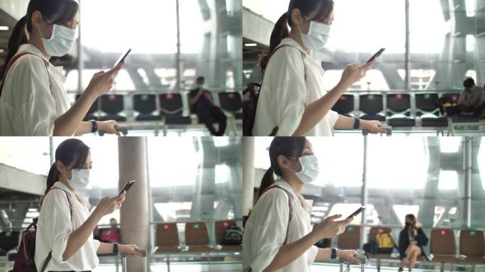 亚洲妇女在机场柜台使用智能手机时戴口罩