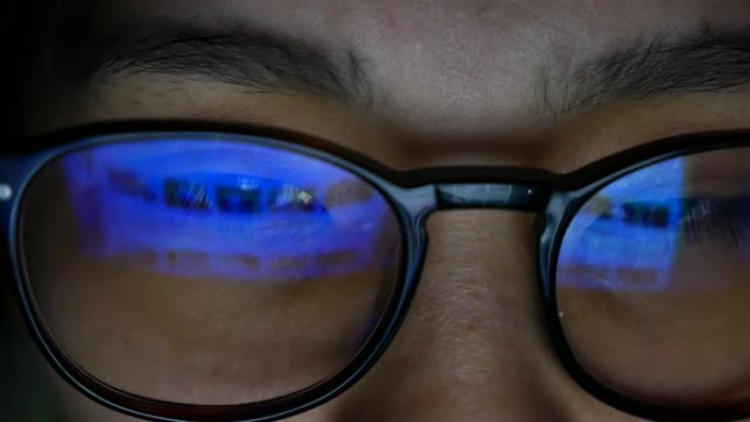 亚洲女人看着电脑镜片反射观看电脑眼镜玻璃