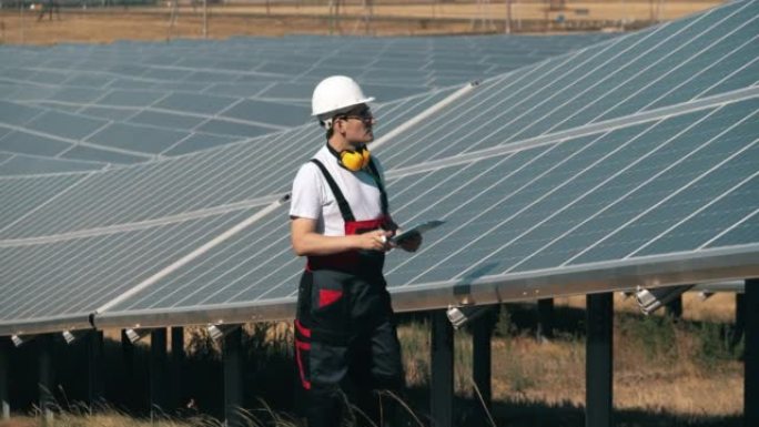 男技术员正在检查太阳能电池板。太阳能工厂附近的替代能源工人。