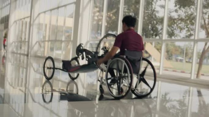 亚洲瘫痪男子推着自行车。