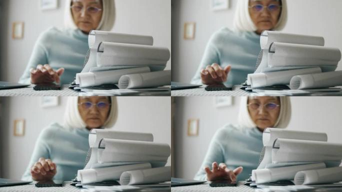 老年妇女在笔记本电脑上支付账单或做家庭财务