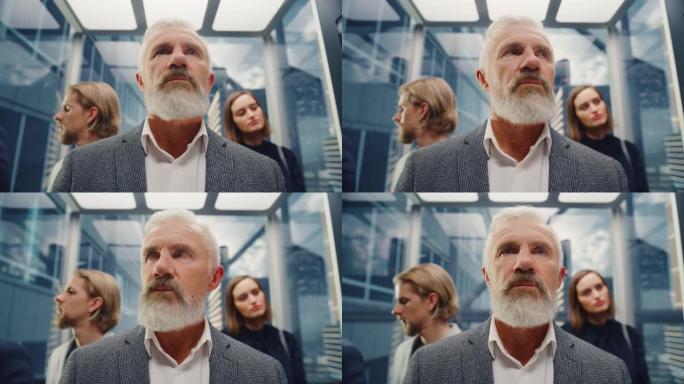 一位自信的中年成功商人在现代商务中心拥挤的玻璃电梯中骑行的肖像。高级经理在乘电梯去办公室的路上。