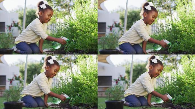 快乐的非洲美国女孩园艺，在花园里浇水