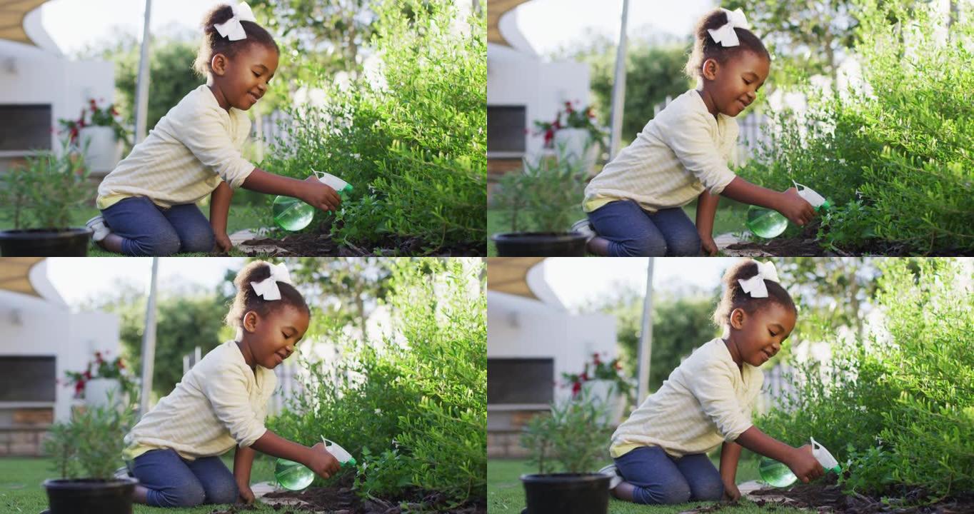 快乐的非洲美国女孩园艺，在花园里浇水