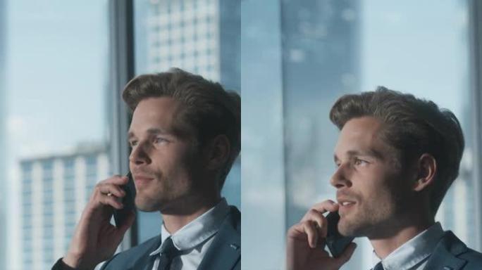 垂直屏幕: 穿着西装的自信商人站在现代办公室，打电话，看着窗外的摩天大楼。成功的财务经理计划工作项目