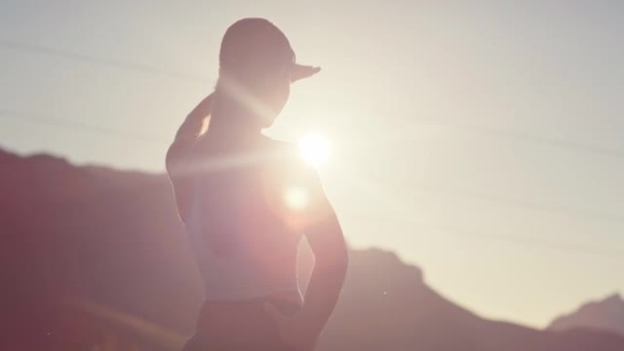 4k视频片段，一名年轻女子在日落时在乡村的道路上奔跑