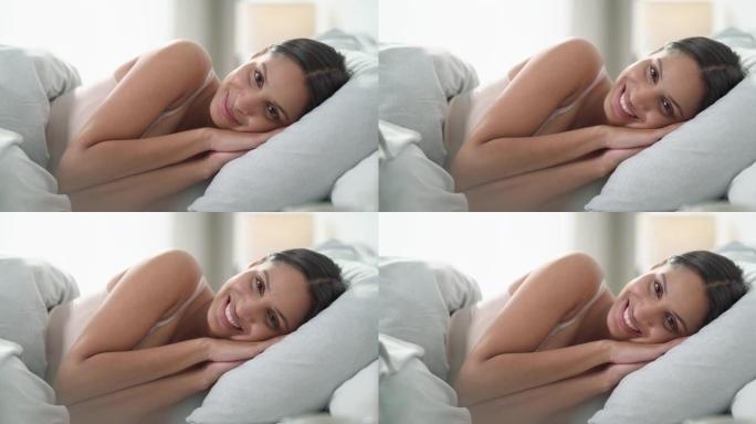 4k视频片段，一名年轻女子早上在家躺在床上放松