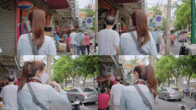 亚洲成年妇女在当地旅游场所散步和购物。迷人的女性在当地旅行时寻找街头美食。单人旅行者概念。