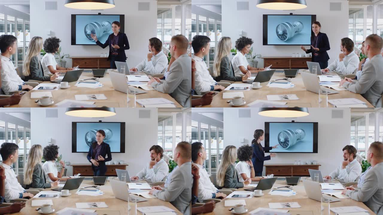 会议室会议的商务人士工程师女士在电视屏幕上介绍涡轮机设计与同事分享技术简报，讨论办公室演示中的想法