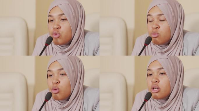穆斯林妇女在政治新闻发布会上用麦克风讲话