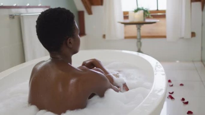 非裔美国迷人女性在浴室泡沫浴缸中放松的背景图