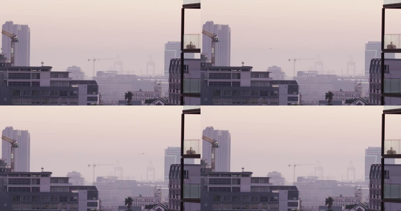 多栋建筑物、建筑工地和造船厂被雾覆盖的城市景观的总体视图