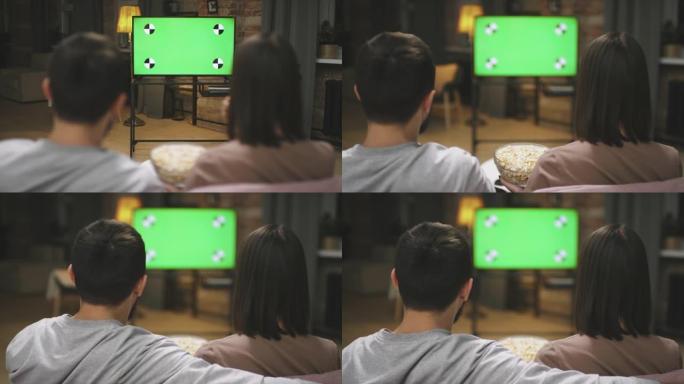 夫妇在电视上观看足球比赛