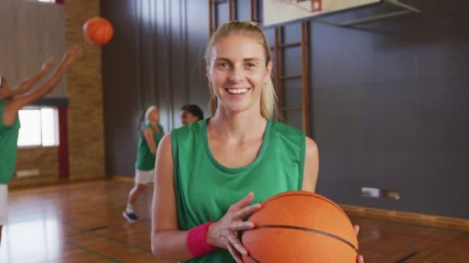 背景为队友的高加索女子篮球运动员肖像