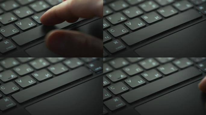 黑色笔记本电脑键盘的特写镜头和一只人手在框架中出现和消失