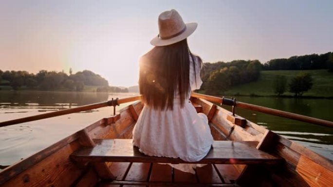 慢动作年轻女子在木船上划过湖面
