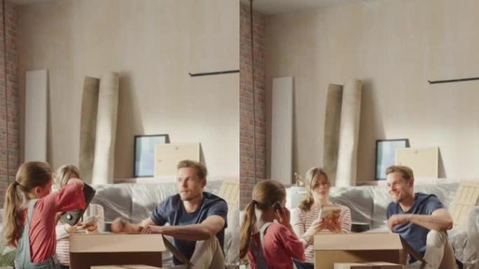 垂直屏幕: 快乐的房主搬进来: 可爱的夫妇坐在舒适公寓的地板上打开纸板箱，小女儿加入了他们的行列。欢