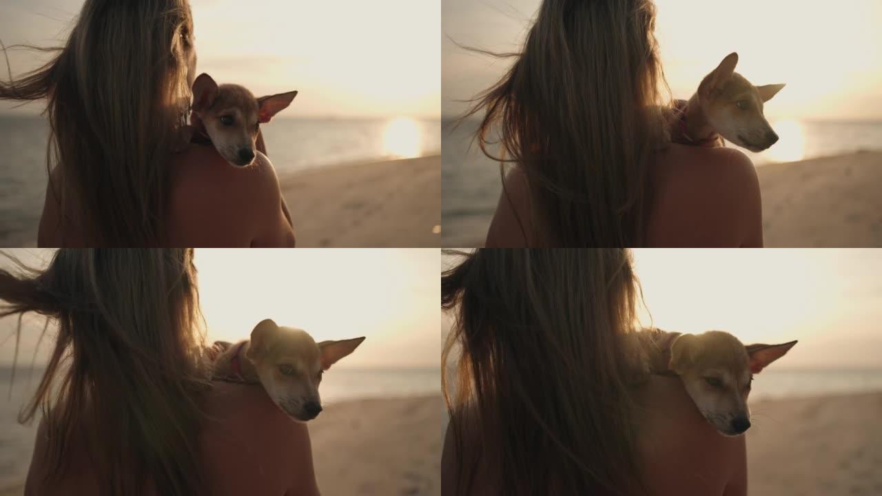 年轻女子和她的小狗一起在海滩上享受