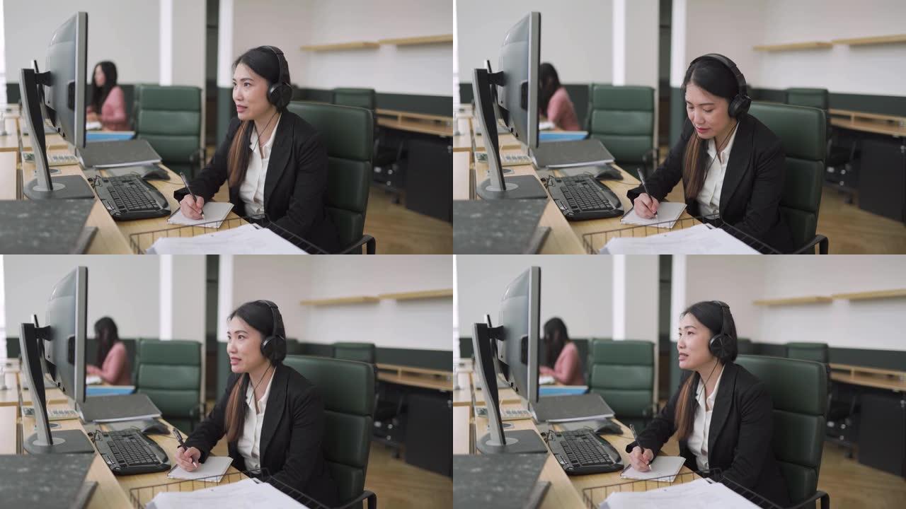 在公开办公室工作的亚洲中国中年女性在网上与客户交谈时写下信息