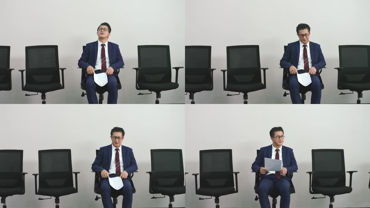 沮丧的亚洲求职者坐在椅子上等待面试