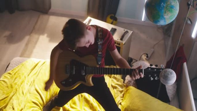 青少年在床上弹吉他