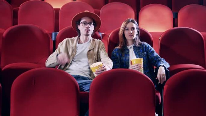 男人和女人在电影院吃爆米花