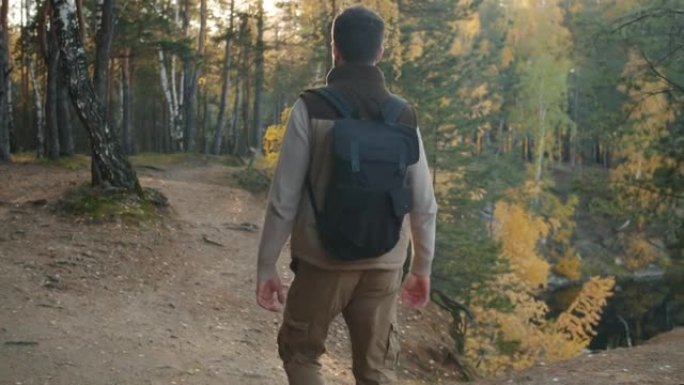 男性游客独自漫步在森林中享受秋天的自然风光