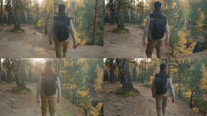 男性游客独自漫步在森林中享受秋天的自然风光