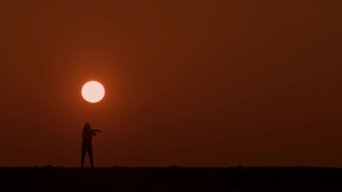 剪影中的SLO MO WS女人在日落时做伸展运动