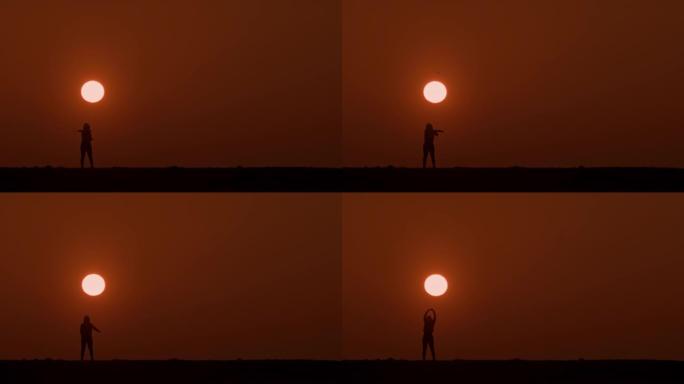 剪影中的SLO MO WS女人在日落时做伸展运动